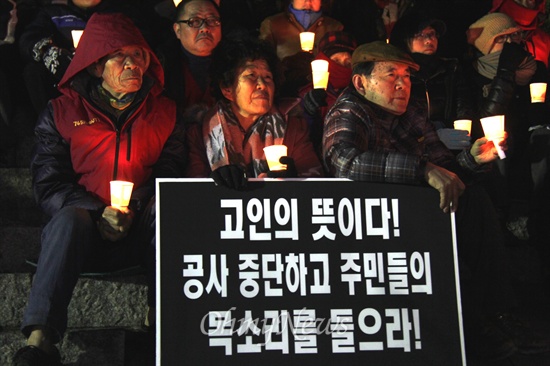  음독 자살한 밀양 송전탑 공사 반대 주민 고 유한숙(74) 할아버지를 기리는 '제1회 추모제'가 11일 저녁 밀양 영남루 계단에서 열렸는데, 주민들이 촛불을 들고 앉아 있다.