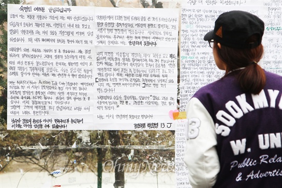 지난 17일 서울 용산구 숙명여대 명신관 앞 게시판에 부착되어 있는 '안녕들하십니까' 대자보를 한 학생이 읽고 있다.