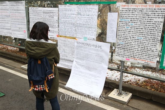 17일 서울 용산구 숙명여대 명신관 앞 게시판에 부착되어 있는 '안녕들하십니까' 대자보를 학생이 지나가며 보고 있다.