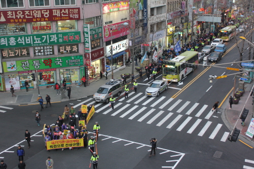 박근혜 사퇴를 촉구하는 대중집회 행진 참가자들이 전주 시내 일명 '관통로 사거리'를 지나고 있다. 이곳은 2008년 광우병 촛불 당시 1만명의 시민들이 촛불을 들었던 장소로 유명하다.