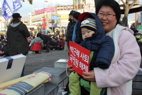 집회에 참가한 한 시민이 아기를 안고 사진기자들에게 활짝 웃음을 보였다. 