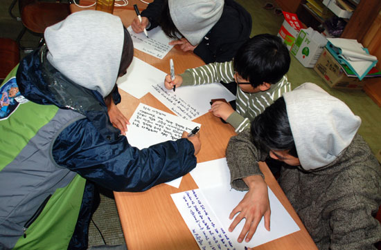 밀양에 거주하는 초등학생과 청소년들이 편지를 쓰고 있다. 
