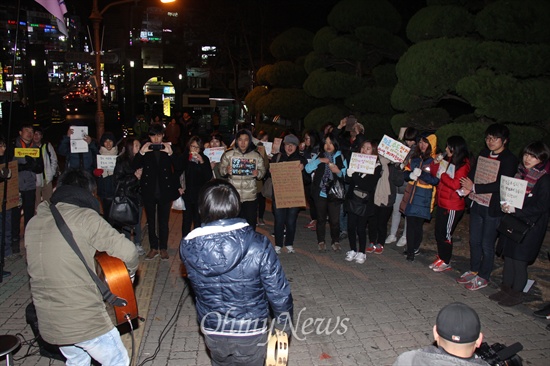  19일 저녁 창원 마산합포구 소재 경남대 정문 쪽에서 열린 "창원, 안녕하지 못한 사람들의 나들이" 행사에 참석한 사람들이 노래패 '더 없는 살림에'의 공연을 듣고 있다.