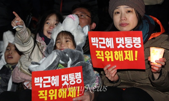 대선 1주년을 맞은 19일 오후 서울광장에서 열린 '관권·부정선거 1년, 민주주의 회복 국민대회'에 참가한 한 가족이 '박근혜 댓통령 직위해제'를 요구하는 피켓을 들고 있다.