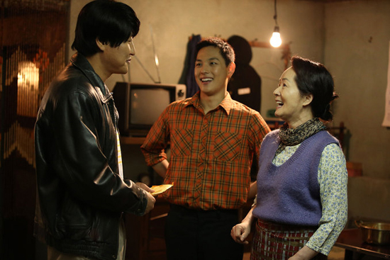  영화 <변호인>의 한 장면. 국밥집 주인과 아들을 만나 인사하는 송우석 변호사