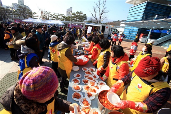  20일 경남은행 봉사대와 대한적십자사 경남지사 자원봉사자 100여명이 마산역을 찾은 지역민들에게 동지 팥죽을 대접하고 있다.