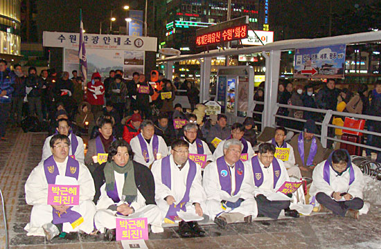 18대 대선 1주년을 맞은 19일 저녁 수원역 광장에서 열린 ‘부정선거 무효, 박근혜 정권 퇴진 촉구 시국기도회’에서 참석자들이 박영모 목사의 설교를 경청하고 있다.
