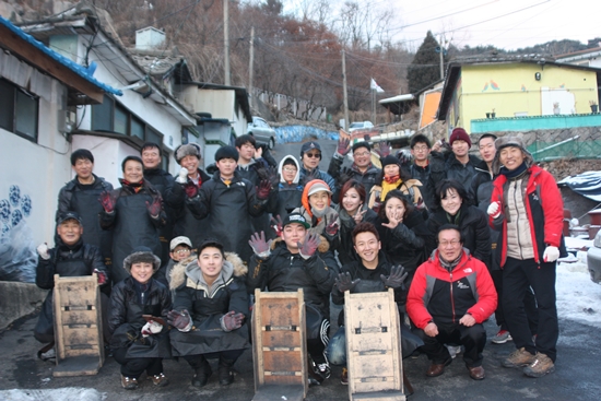 '개미마을'에서 사랑의 연탄나눔 활동에 참가한 자원봉사자들이 기념 촬영을 했다