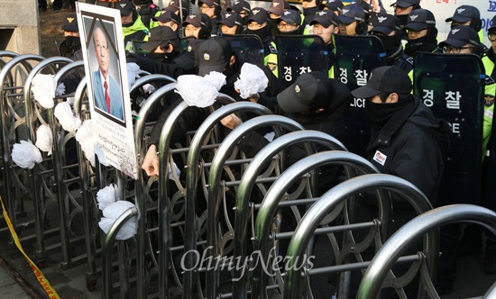 고 유한숙씨 추모 조화 제거하는 한전 고 유한숙씨 유가족과 밀양 송전탑 건설을 반대하며 상경한 밀양 주민들이 20일 오후 서울 강남구 한국전력공사 본사 정문에 고인을 추모하며 조화를 매달아놓자, 한전 관계자들이 이를 제거하고 있다.