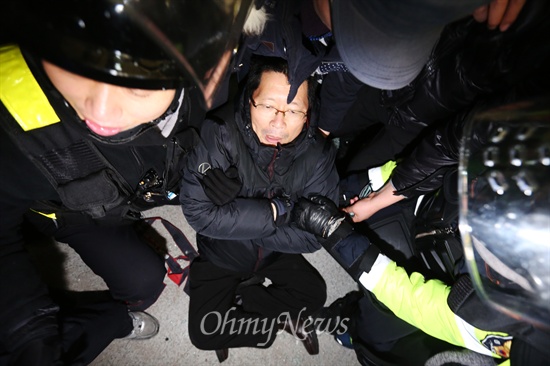 오병윤 통합진보당 원내대표가 22일 민주노총이 입주해있는 경향신문 1층 입구에서 진입을 시도하는 경찰 병력이 끌어내려하자 저항하고 있다.