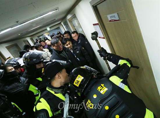 22일 민주노총에 진입한 경찰병력이 회의실 문을 망치로 부수고 수색하고 있다.