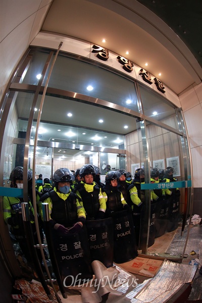 철도노조 지도부를 체포하기 위해 민주노총이 입주한 서울 정동 경향신문사 건물에 22일 경찰이 투입된 가운데 집입작전 도중 파손한 유리문쪽에 경찰들이 방패를 들고 배치되어 있다.