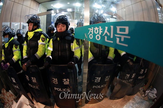 22일 경찰이 철도노조 지도부를 체포하기 위해 민주노총이 입주한 서울 정동 경향신문사 건물에 병력을 투입한 가운데, 집입작전 도중 파손된 유리문쪽에 경찰들이 방패를 들고 서있다.