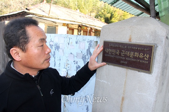  이기동 민족문제연구소 진주지회장이 최근 문화재청에서 등록말소한 진주 드무실 '남인수 생가'를 둘러보고 팻말을 만져보고 있다.