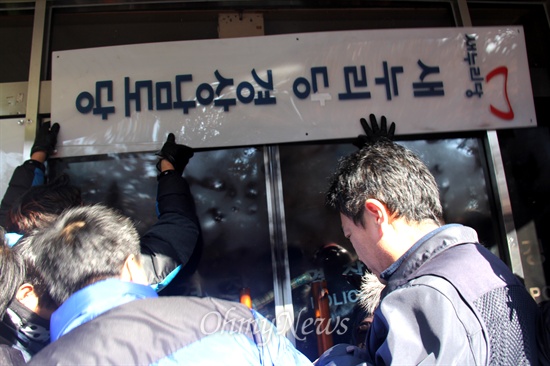 민주노총 경남본부 조합원들은 2013년 12월 23일 오후 새누리당 경남도당 간판을 뜯어냈다.