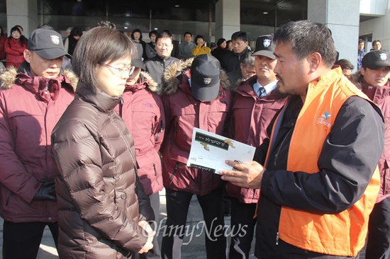  박석용 전국보건의료산업노동조합 진주의료원지부장이 23일 오전 경남도청 현관 앞에서 홍준표 지사한테 전달해달라며 정약용 선생의 <목민심서>를 윤성혜 경남도 복지보건국장(왼쪽)한테 전하며 설명하고 있다.