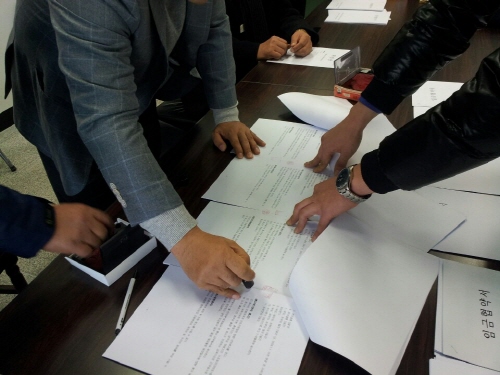 민주노총 공공운수노조 전북지역버스지부와 전주시내버스 3개사가 23일 2013년 임금 및 단체협약을 체결했다. 노사가 협약서에 도장을 찍는 장면. 