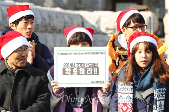 산타복장의 대학생들이 24일 국회 앞에서 국가장학금 예산을 증액하라며 박근혜 대통령의 '반값등록금' 공약 이행을 촉구하는 퍼포먼스를 벌이고 있다.
