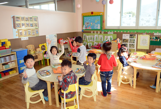 아이들이 교실에 앉아 맛있게 점심을 먹고 있다.