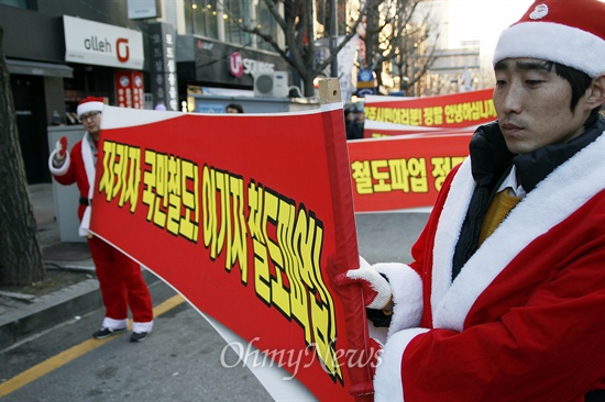  경찰이 철도노조 지도부 체포를 위해 1995년 민주노총 설립 후 처음으로 민주노총 건물에 공권력을 투입한 가운데 민주노총 광주지역본부가 이에 항의하는 '7보 1배' 시위를 24일 벌였다. 크리스마스를 하루 앞둔 이날 산타 복장을 한 시위 참가자도 보였다. 이들은 7보 1배를 하는 참가자 뒤편에 서 "지키자 국민철도! 이기자 철도파업!"이라고 적힌 플래카드를 들고 행진했다.
