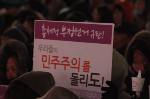 "총체적 부정선거 규탄, 우리들의 민주주의를 돌리도"라고 적힌 종이피켓.