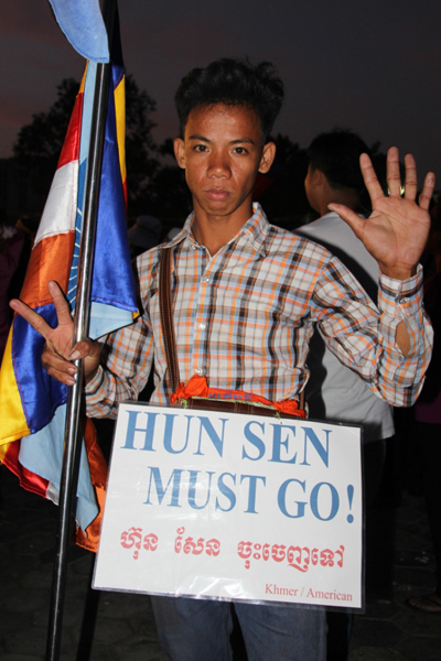 한 시위 참가자가 지난 27일 오후 훈센총리 퇴진을 요구하는 피켓을 들고 서 있다. 
