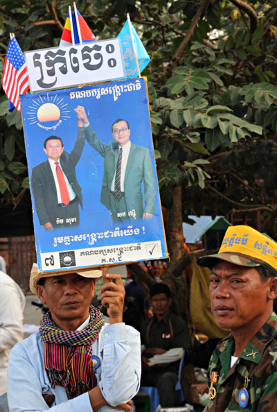 27일 집회 참가자들이 현 통합야당(CNRP)의 두 지도자인 삼 랭시와 켐 소카의 사진이 담긴 피켓을 들고 있다. 