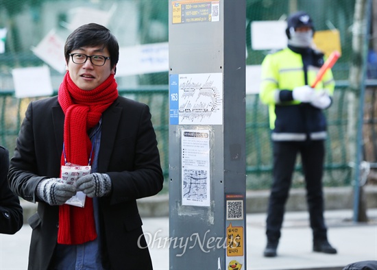 '안녕들하십니까'로 알려진 주현우씨가 28일 서울 중구 산업은행 앞에서 에 열린 '뜨거운 안녕' 집회에 참석하고 있다. 같은 모습으로 뒷 편에 경찰이 서 있다.
