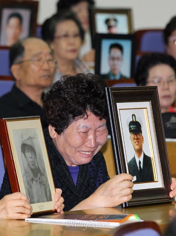 군대 보낸 자식을 잃은 '군 의문사' 유족들이 5월 24일 오전 국회 의원회관에서 열린 호소대회에서 아들의 영정을 들고 진상규명과 명예회복을 촉구하며 흐느끼고 있다.