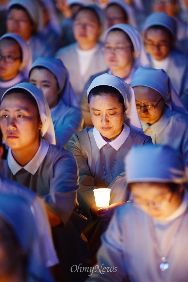 9월 23일 오후 서울광장에서 천주교정의구현사제단 주최로 '국정원 해체 민주주의 회복 시국미사'가 열리는 가운데, 한 수녀가 촛불을 들고 미사에 참여하고 있다.