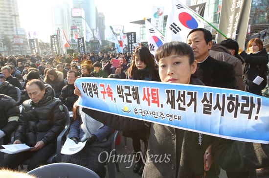 "이명박 구속, 박근혜 사퇴, 재선거 실시하라" 서울역 앞 고가도로 위에서 '박근혜 사퇴, 특검 실시'를 외치며 분신해 숨진 고 이남종 열사의 영결식이 4일 오전 서울 중구 서울역 광장에서 민주시민장으로 엄수된 가운데, 한 시민이 '이명박 구속, 박근혜 사퇴, 재선거 실시하라'라고 적힌 피켓을 들어보이고 있다.