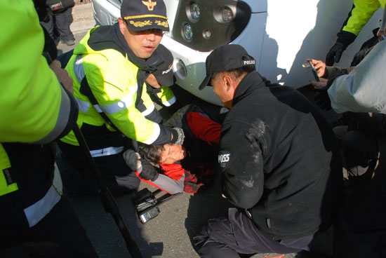 경찰버스 밑 주민 송전탑 건설 반대주민이 경찰버스 밑으로 들어가 저항하고 있다.