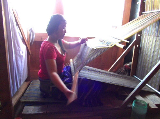 수동식으로 직물을 짜는 모습. 우리나라 베틀과 유사하다(팀푸 국립텍스타일박물관)