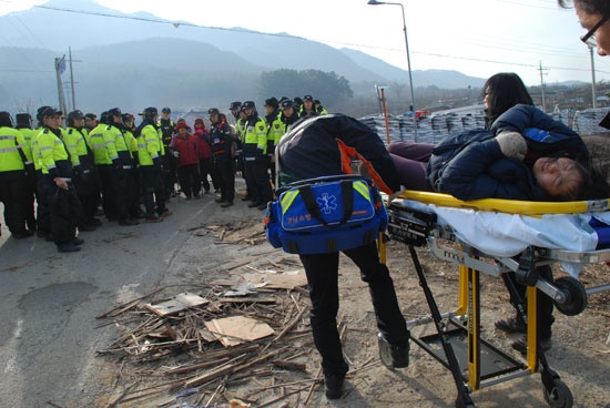 한 시민이 부상을 입어 119에 의해 병원으로 이송되고 있다. 7일 오전 밀양 송전탑 건설 현장에서는 경찰과 주민이 충돌했다. 