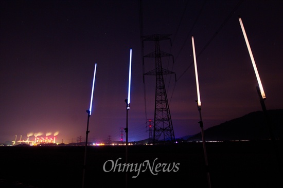  6일 오후 충남 당진 왜목마을 일대에 설치된 765kV 송전탑 아래에서 전자파의 영향을 실험하기 위해 설치한 형광등이 반응을 일으키고 있다.