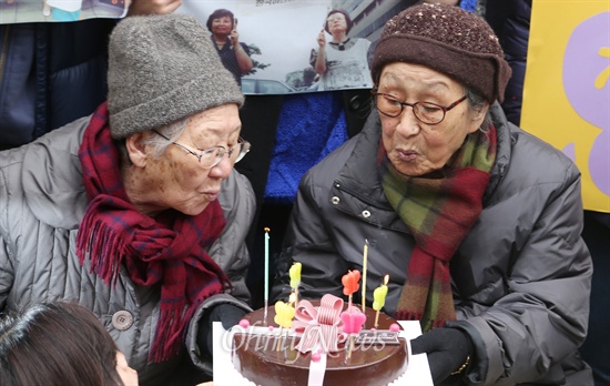 길원옥(왼쪽), 김복동 할머니가 8일 오전 서울 중구 일본대사관 앞에서 열린 22주년 '수요집회'에 참석해 수요집회 22주년 기념 케익의 불을 끄고 있다. . 이 집회는 1992년 1월 8일 시작되 1108차를 맞고 있다.
