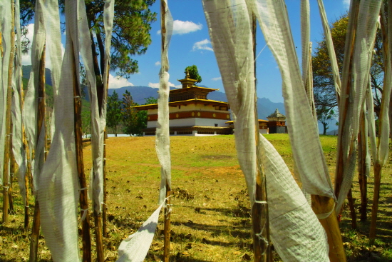 룽다 사이로 보이는 치미라캉사원. 치미라캉사원은 다산과 번영을 기원해주는 사원으로 부탄인들 사이에 널리 알려져 있다. 아이가 없는 부부도 이 사원에서 불공을 드리면 아이를 갖게된다고 한다. 