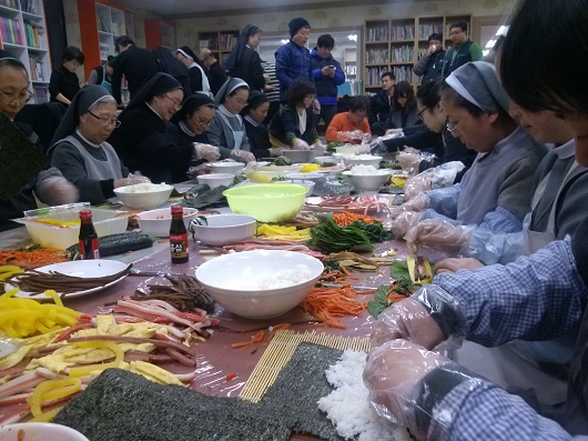  와락에 모인 신부, 수녀들이 김밥을 싸고 있다. 
