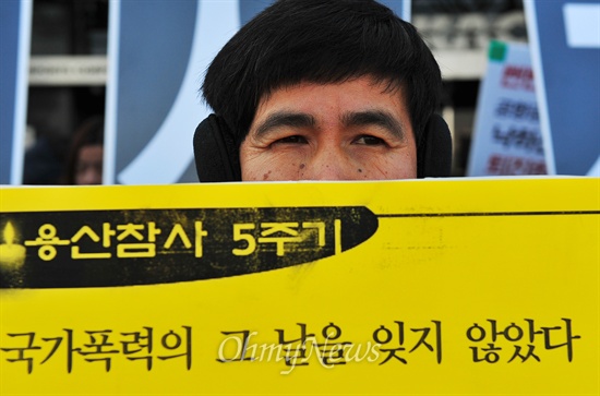 용산참사 5주기를 앞두고 15일 오전 서울 강서구 한국공항공사 앞에서 김석기 사장의 퇴진과 처벌을 요구하던 한 참가자가 참사 당일의 악몽을 떠올리며 비통한 표정을 짓고 있다.