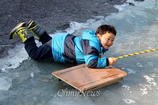 얼음썰매장에서 썰매를 타면서 즐거워하는 어린이.
