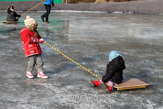 얼음썰매장에서 썰매를 타면서 즐거워하는 아이들.