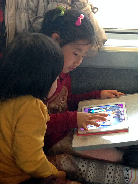 KTX 열차 안에서 아이패드 에어로 애니메이션 앱을 보고 있는 아이들