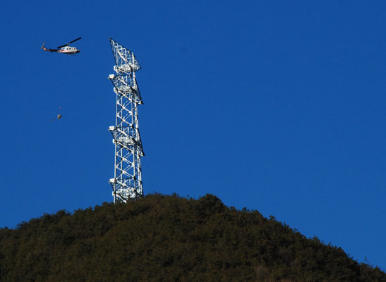밀양시 부북면 위양리 마을 뒷동산에 세워진 765kv 송전탑 뒤로 송전탑 건설 공사자재를 실은 헬기가 지나가고 있다.
