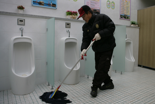 한추향 어르신이 진도 충무공공원에 있는 공중화장실을 청소하고 있다.
