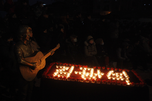 김광석 다시그리기길에 놓여진 김광석 동상과 그의 탄생을 축하하는 촛불. 김광석이라고 적힌 촛불 50개가 타고 있는 모습.