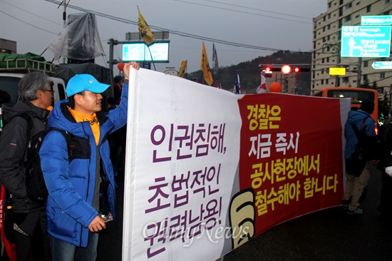  2차 밀양 희망버스 참가자들이 경찰의 인권침해를 규탄하는 내용의 펼침막을 들고 한국전력공사 밀양지사 앞에 서 있다.