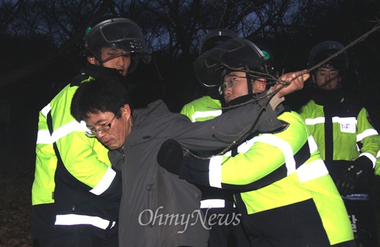 2차 밀양 희망버스 참가자들이 26일 오전 6시경 밀양시 단장면 동화전마을에 있는 97번 송전탑 공사장으로 오르다가 경찰과 충돌했는데, 한 참가자가 경찰에 밀려 내려오고 있다.