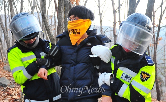 26일 오전 경남 밀양에서 진행된 '2차 희망버스' 참가자들이 송전탑으로 올라가자 경찰들이 한 시민을 끌어내고 있다. 