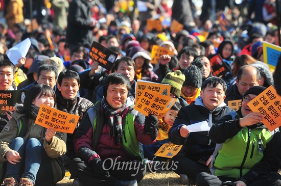 26일 오전 송전탑을 반대하는 희망버스 행사가 열리는 가운데 경남 밀양 영남루 인근에서 열린 기자회견에서 참가자들이 구호가 적힌 팻말을 흔들고 있다. 