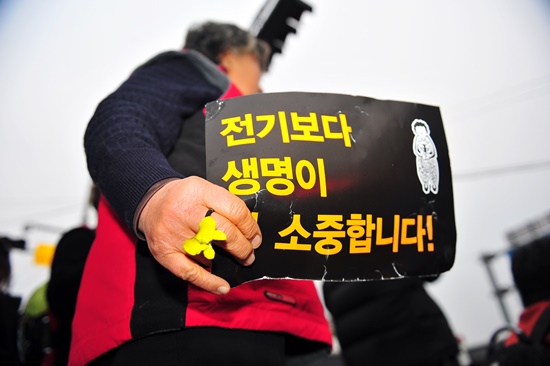 25일 오전 서울 중구 대한문 앞에서 송전탑 설치를 반대하는 '밀양 희망버스' 한 참가자가 구호가 적힌 팻말을 들고 있다.